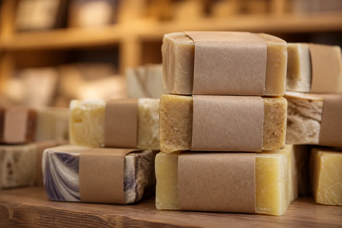 Gros plan sur des étiquettes kraft détaillant la composition de savons empilés dans une boutique